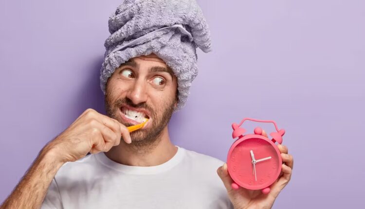 مسواک زدن مرد با ساعت قرمز در دست
